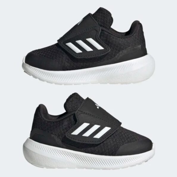 נעלי ספורט לאדידס תינוקות בצבע שחור לבן עם סגירת סקוץ זווית מהצד על רקע אפור